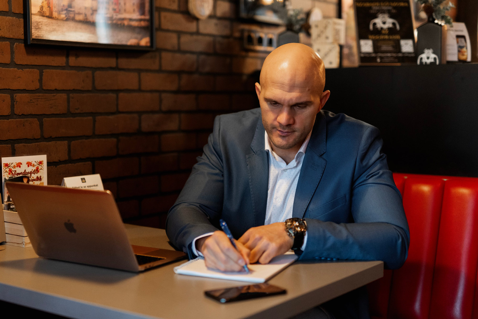 Illés Álmos laptop mellett jegyzetel az Éhes Vikingben